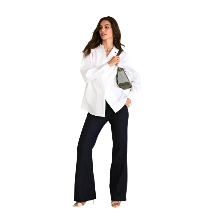 Woman wearing a white blouse and black pants holding a handbag on a white background