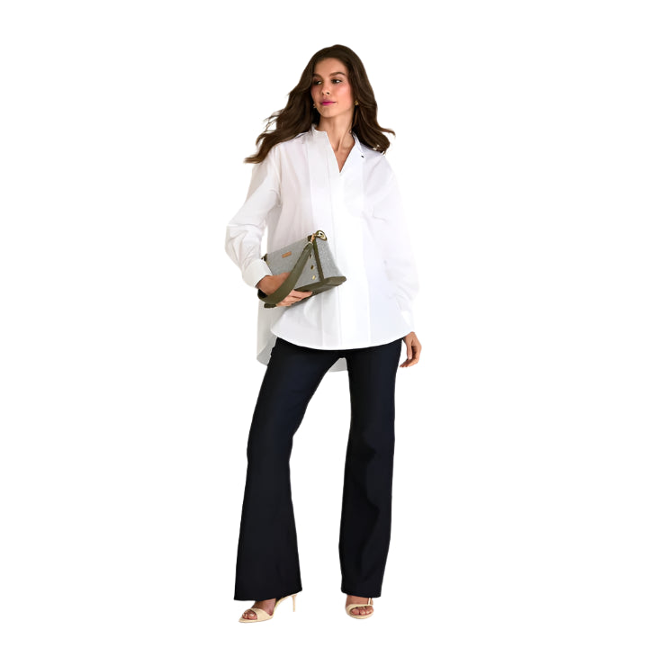Woman wearing a white blouse and black pants holding a clutch on a white background