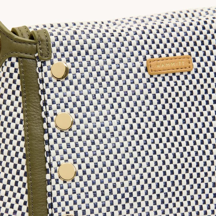 Close-up of a checkered bag with gold buttons and a brand label.
