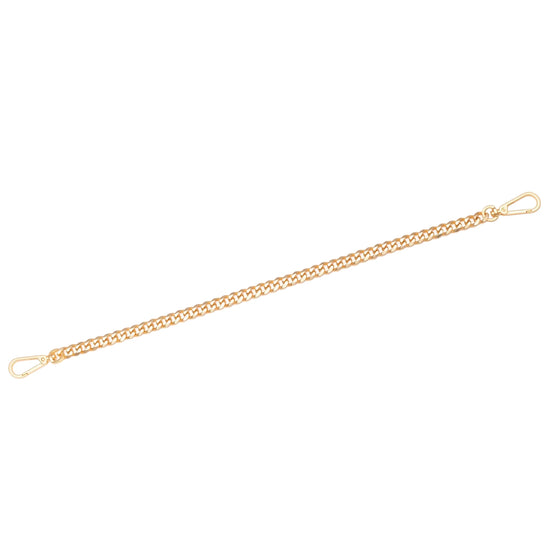 Gold chain bracelet on a light beige background