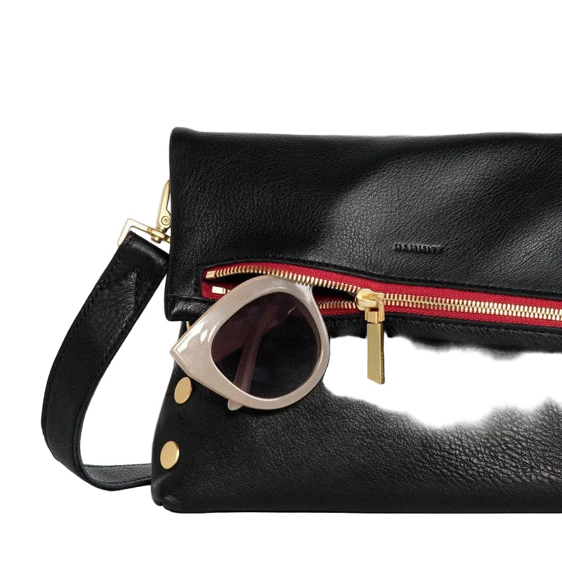 Black leather handbag with gold accents and sunglasses on a white background