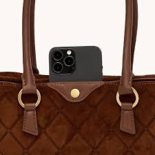 Smartphone on a brown quilted handbag with gold rings