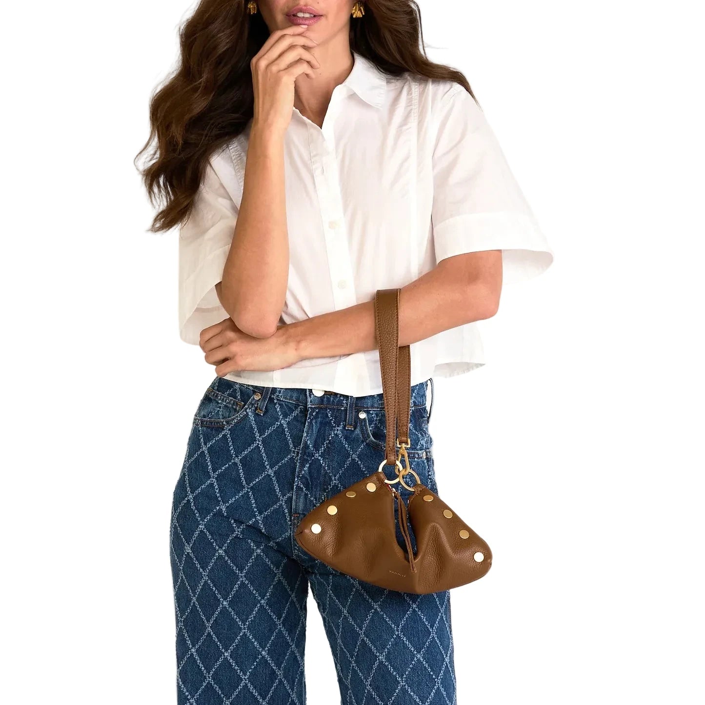 Woman holding a brown handbag against a white background