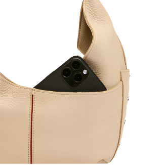 Beige leather handbag with a black phone inside on a white background