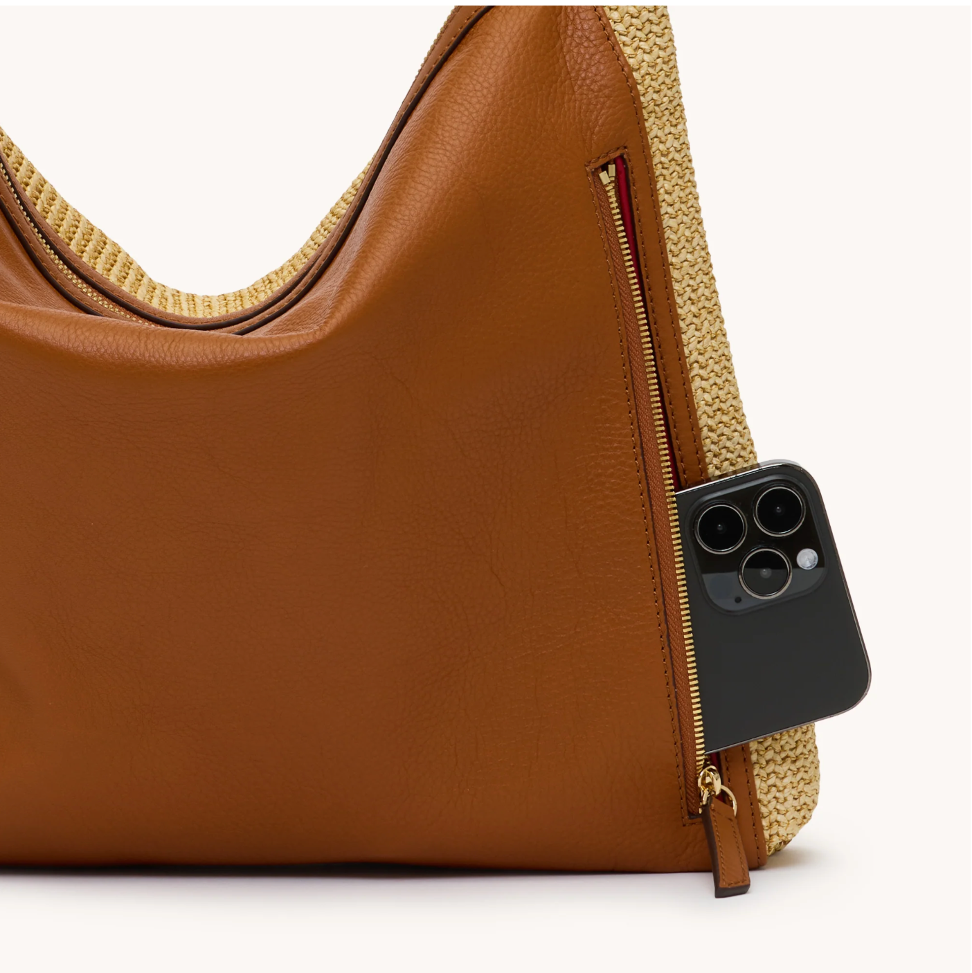 Brown leather handbag with a phone inside on a white background