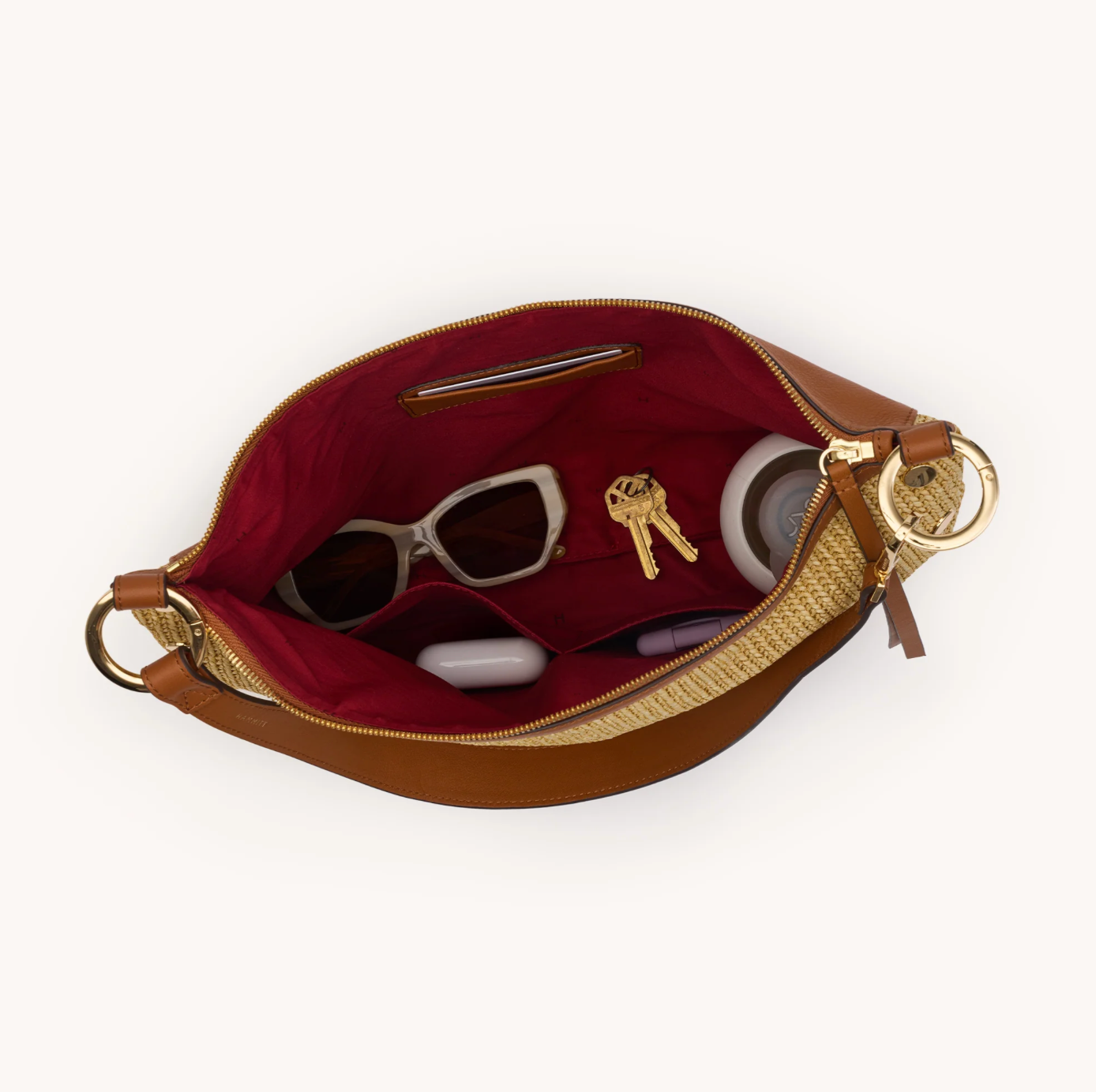 Brown handbag with gold zipper and handle on a white background