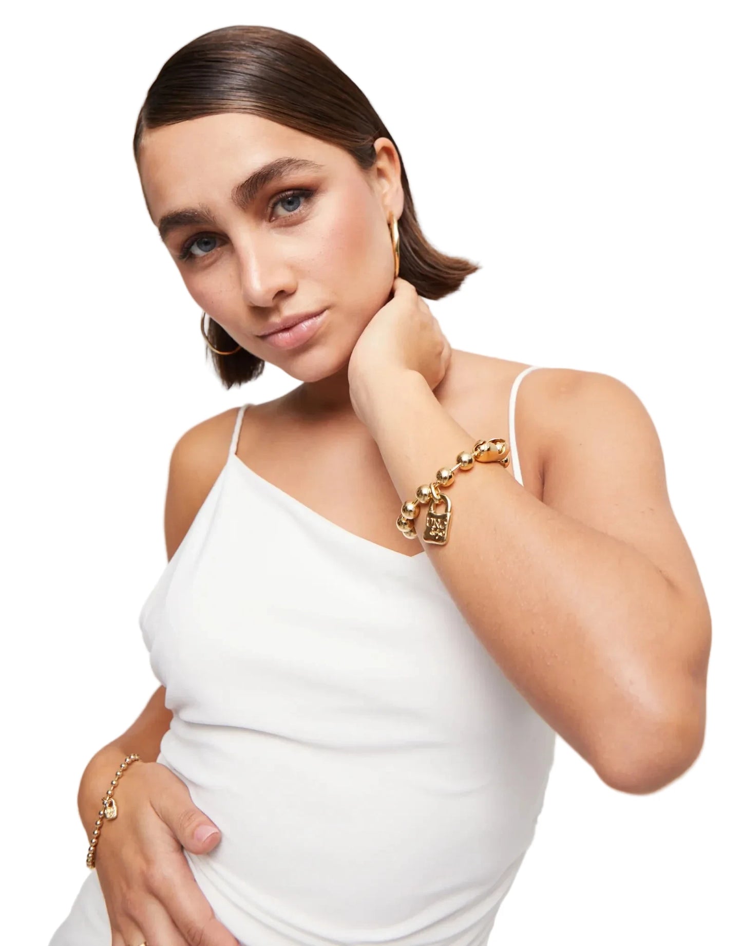 Woman wearing gold jewelry against a white background