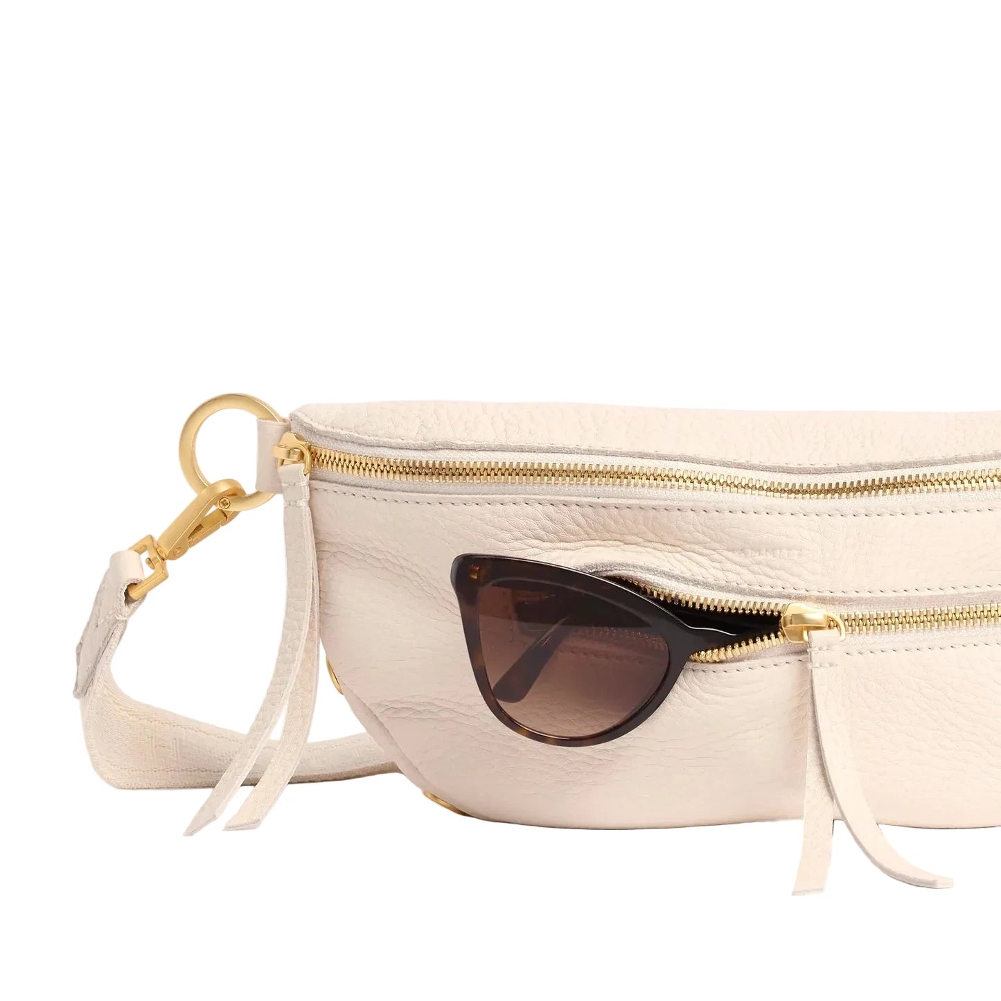 Cream leather bag with sunglasses inside on a white background