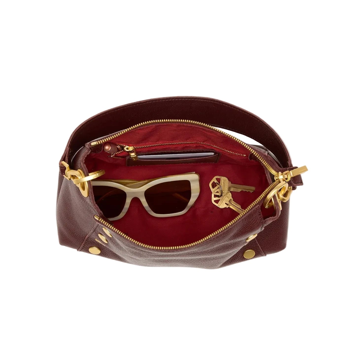 Inside view of maroon handbag with gold zipper and sunglasses on a white background